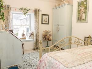 a bedroom with a bed and a window at Wonderland Cottage in Cupar