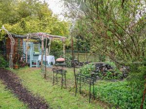 un patio trasero con sillas y una parrilla en el patio en Wonderland Cottage, en Cupar