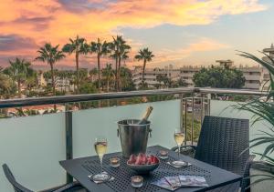 a table with a bowl of fruit and wine glasses on a balcony at AxelBeach Maspalomas - Apartments and Lounge Club - Adults Only in Playa del Ingles