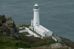 een vuurtoren bovenop een heuvel naast de oceaan bij Applebys Guest House in Holyhead