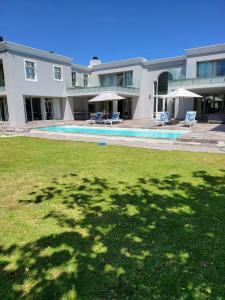 a large white house with a large yard with a pool at The Grandstancia in Cape Town