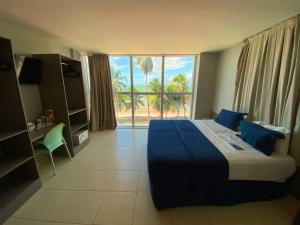 1 dormitorio con cama y ventana grande en Flat Beira Mar do Cabo Branco Quarto com linda vista para o mar, en João Pessoa