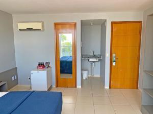 1 dormitorio con 1 cama y baño con lavamanos en Flat Beira Mar do Cabo Branco Quarto com linda vista para o mar, en João Pessoa