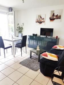 a living room with a couch and a table at SUPERBE APPART AVEC JARDIN ET PISCINE in Cambo-les-Bains