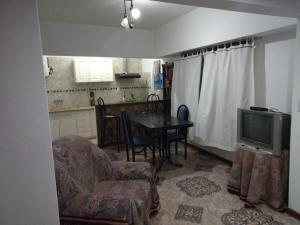 sala de estar con TV, mesa y sillas en CASA PARA 6 PERSONAS EN SAN BERNARDO en San Bernardo