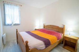 1 dormitorio con cama de madera y ventana en L'Isard, en Barèges