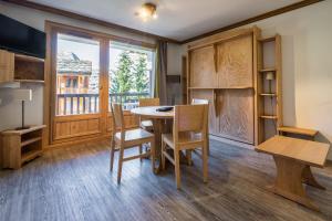 een eetkamer met een tafel en stoelen en een raam bij Solaise in Val dʼIsère