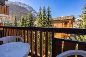 a balcony with a table and a view of a mountain at Solaise in Val dʼIsère