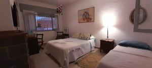 Un dormitorio con dos camas y una mesa con lámpara. en Bed & Breakfast Pleno Centro EN CASA PARTICULAR, en San Luis
