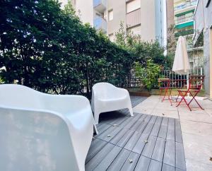 a pair of white chairs sitting on a patio at NEW - Nuovo appartamento in centro in San Donato Milanese