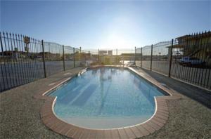 a swimming pool next to a fence with a fence at Travelodge by Wyndham New Braunfels in New Braunfels