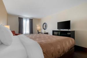 a hotel room with a bed and a flat screen tv at Quality Inn Phenix City Columbus in Phenix City