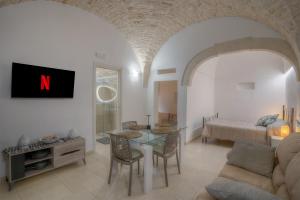 a living room with a table and a bed at Home Pedra in Ceglie Messapica