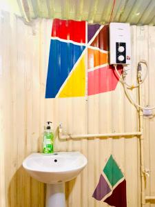 a bathroom with a sink and a colorful wall at Saigon Garden Homestay in Ho Chi Minh City +88 photos