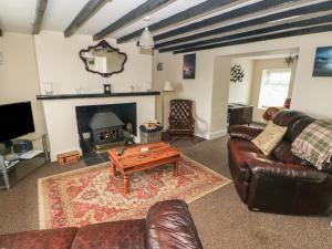 a living room with leather furniture and a fireplace at Nash Lodge in Pembroke Dock