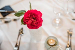 una rosa roja en un jarrón sobre una mesa en Hotel Crystal - KitzHorn Suites, en Sankt Johann in Tirol