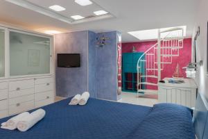 1 dormitorio con 1 cama azul y toallas blancas en Cambusa del Capitano, en San Vito lo Capo