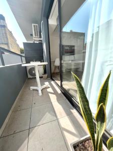 balcón con mesa blanca y ventana en Cozy & sunny studio in Saavedra en Buenos Aires
