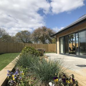 a garden with flowers and a bench in a yard at Bailgate Barn, Ashlin Farm Barns in Lincoln