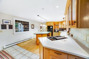 a kitchen with wooden cabinets and a white counter top at Willard Road Hideaway in Quechee