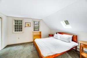 a bedroom with a bed and two windows at Willard Road Hideaway in Quechee