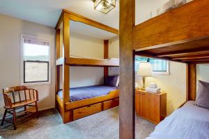 um quarto com 2 beliches e uma cadeira em Comstock Retreat em Sea Ranch