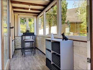 a screened in porch with a bar and a table at Refuge de l'Ecureuil in Métabief