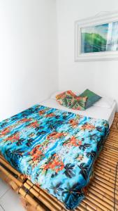 łóżko z kolorowym kocem i oknem w obiekcie Casa Tuxi w mieście Rio de Janeiro