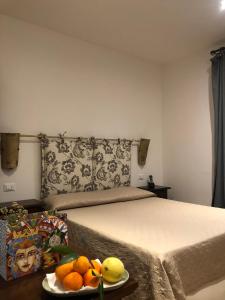 ein Schlafzimmer mit einem Bett und einem Obstteller auf dem Tisch in der Unterkunft B&B Villa Alba in San Vito lo Capo