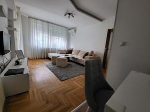 sala de estar con sofá y mesa en Apartman KostaS, en Lukavica