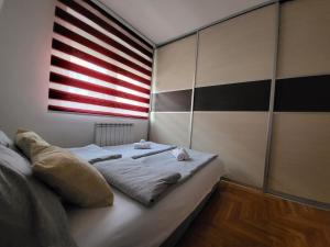Cama en habitación con bandera americana en Apartman KostaS, en Lukavica