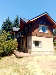 a house on a hill with a yard at Aparts chalet Alquimia in Lago Puelo