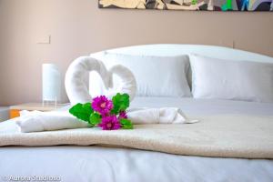 um animal de toalha feito de toalhas e flores numa cama em B&B L'incanto degli Artisti em Caltagirone