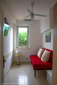 uma sala de estar com um sofá vermelho e uma janela em B&B L'incanto degli Artisti em Caltagirone