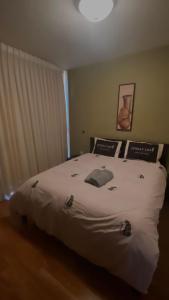 1 dormitorio con 1 cama grande con sábanas y almohadas blancas en יולי גולף en Caesarea