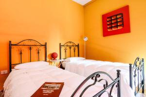 2 letti in una camera con pareti gialle di B&B Casa Fuori Casa 200 mt dal casello autostradale a Senigallia
