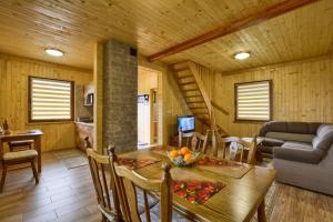 uma sala de jantar e sala de estar num chalé de madeira em Oaza Spokoju - Domki em Polanica-Zdrój