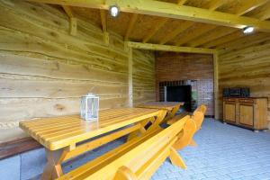 un tavolo e delle panche di legno in una baita di tronchi di Oaza Spokoju - Domki a Polanica-Zdrój Altre 6 foto