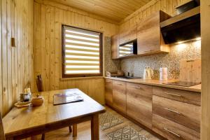 una cucina con mobili in legno e un tavolo in legno di Oaza Spokoju - Domki a Polanica-Zdrój