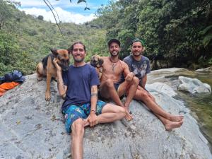 圣拉菲尔La Perla Negra - Black Pearl Eco Hostel的三个男人和他们的狗坐在石头上