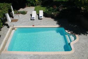 a swimming pool with two lounge chairs in a yard at Queen Manor Boutique Guest House in Graaff-Reinet