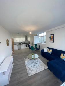 a living room with a blue couch and a table at Flitwick Luxury Apartments in Flitwick