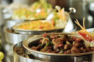 a group of plates of food on a buffet at Pose In Hotel Solo in Solo
