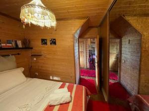1 dormitorio con cama y lámpara de araña en Chalet Επισκοπικό Ιωάννινα Ξύλινο σπίτι σε κτήμα 