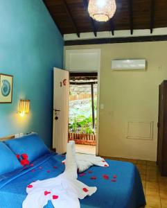 a bedroom with a blue bed with flowers on it at Pousada Encantos do Mar in Arraial d'Ajuda