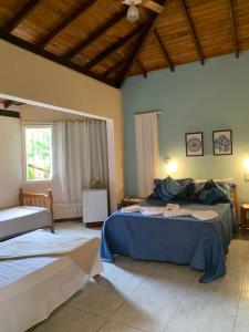 a bedroom with two beds and a ceiling at Pousada Encantos do Mar in Arraial d'Ajuda
