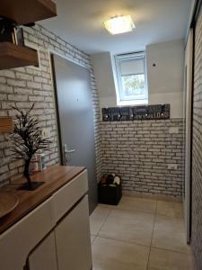 a bathroom with a brick wall and a walk in shower at Apartma GABER 125 - Rogla in Zreče