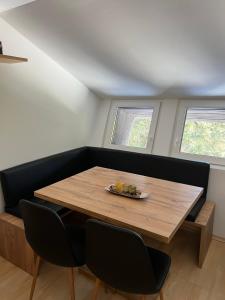 - une salle à manger avec une table en bois et 2 fenêtres dans l'établissement Apartma GABER 125 - Rogla, à Zreče