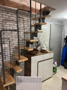 a kitchen with wooden shelves on a brick wall at Apartma GABER 125 - Rogla in Zreče