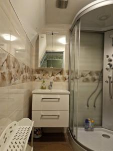 a white bathroom with a shower and a sink and a showerspective at Apartma GABER 125 - Rogla in Zreče